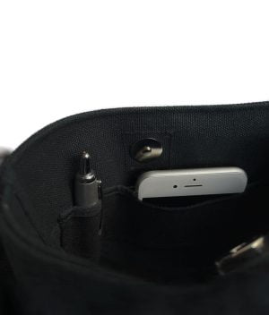Kallo-laukun sisätaskut, joissa toisessa näkyy kuulakärkikynä ja toisesta valkoisen kännykän ylälaita.