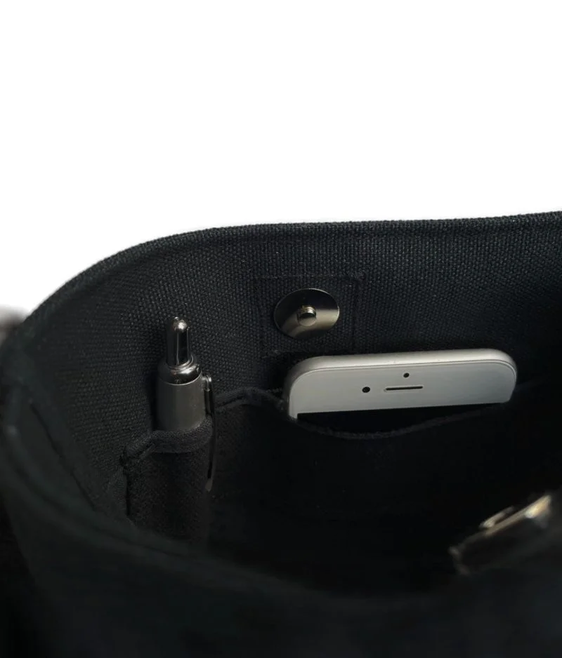 Kallo-laukun sisätaskut, joissa toisessa näkyy kuulakärkikynä ja toisesta valkoisen kännykän ylälaita.