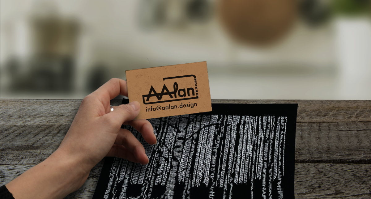 Naisen käsi pitelee käyntikorttia, jossa AAlan Design -logo ja sähköpostiosoite: info@aalan.design