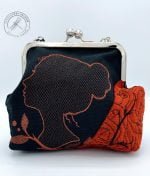 The Purse handcrafted from coppery red upholstery remnant fabric and black cotton fabric with a beautiful woman's silhoutte embroidered with copper metallic thread.