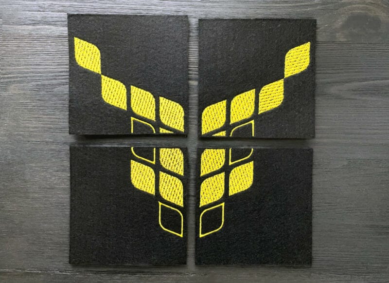 4 lasinalusesta koostuva hiisin keltainen logo mustalla pohjalla.